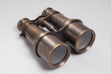 Beyaz arkaplanda eski dürbünlerin yakın plan görüntüsü.    