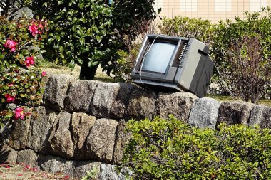 Dışarıdaki taş duvarda duran eski televizyon.