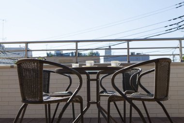 kahve masası ve sandalyeler balkonda.