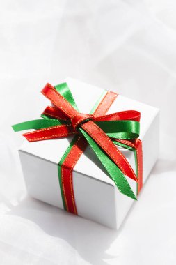 Beyaz arka planda kurdeleli kırmızı bir hediye.