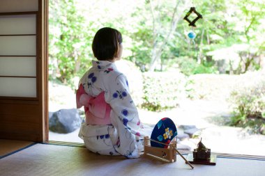 Yerde oturan kimonolu kadın.