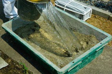 Beton döşeme yapmak için beton karıştırıcı kullanan işçiler.