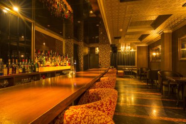 Lüks restoranın içi, rahat kırmızı sandalyelerle dolu.