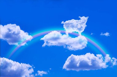 Gökkuşağı ve beyaz tüylü bulut mavi gökyüzü arka planında koyun şeklinde