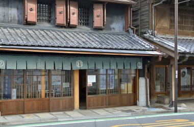 Mimarlık, Japon şehrinin güneşli ana caddesinde davetkar bir koridor oluşturuyor.