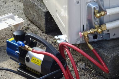 Dışarıdaki kırmızı hortumlarla cihaza bağlı kompresör