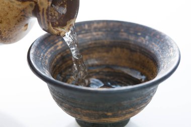 Japon sake 'sini şişeden killi fincana dök