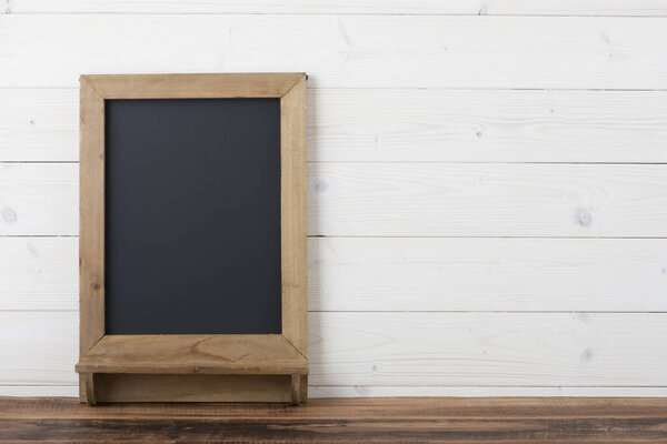 wooden table with blackboard background and empty space.