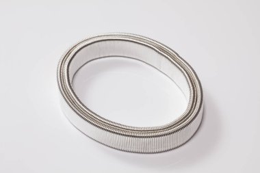 Temiz yüzeyde duran sarmalanmış beyaz mezura.