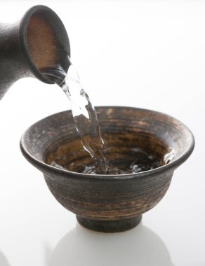 Japon sake 'sini şişeden killi fincana dök