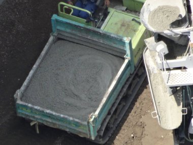 İnşaat alanı, beton karıştırıcı kamyonun malzeme boşalttığını gösteriyor