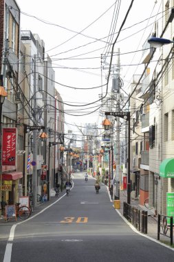 Güneş ışığı, Japon caddesine derinlik katarak binaların zengin dokusunu ortaya çıkarıyor..