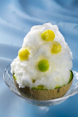 Üstünde kavun topları olan yumuşak tıraşlı buzlu tatlı.