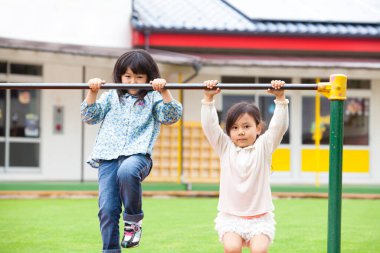 Parkta oynayan iki tatlı Asyalı küçük kız..