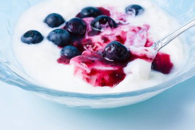 Beyaz fincanda yabanmersinli taze yoğurt.