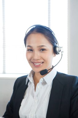 Ofisinde kulaklığı olan mutlu genç çağrı merkezi çalışanı portresi.