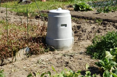 Sebze bitkilerinin arasında duran beyaz gübre kutusu