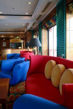 Otel odasının içi parlak ahşap paneller, lambalar ve rahat koltuklarla dolu.