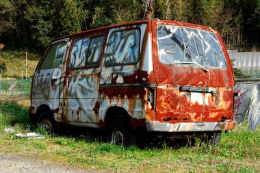 Arka planda terk edilmiş bir araba var, kapatın.