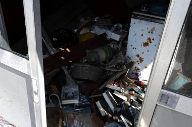 Gün ışığını aydınlatan dağınık terk edilmiş odalar bozuk eşyalarla dolu.