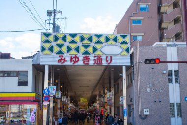 Güneş ışığı, Japon caddesine derinlik katarak binaların zengin dokusunu ortaya çıkarıyor..