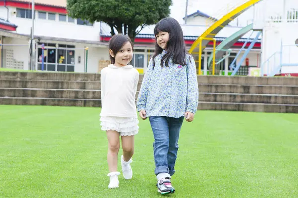 Twee Schattig Aziatische Schoolkinderen Lopen Groen Gras Schoolplein — Stockfoto
