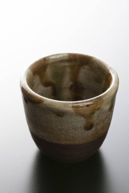 Açık arkaplanda kahverengi seramik kasenin yakın plan görüntüsü         