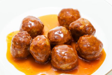 Beyaz tabakta soslu kızarmış köfte yakın plan görüntüsü. 