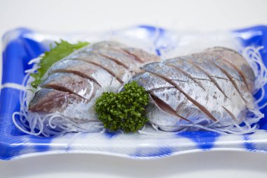 Dilimlenmiş tuzlu ringa balığı ve otlar. 