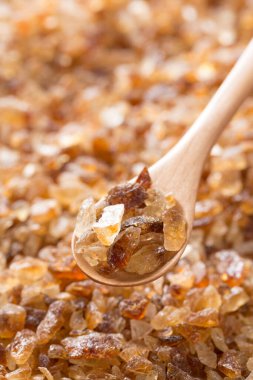 Esmer şeker ve tahta kaşık arka planda, kapatın.