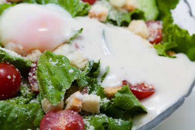 Tabakta kızarmış ekmek ve peynirli taze sezar salatası.