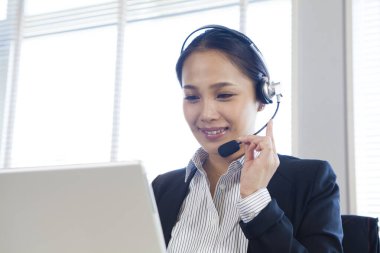 Ofisinde kulaklığı olan mutlu genç çağrı merkezi çalışanı portresi.