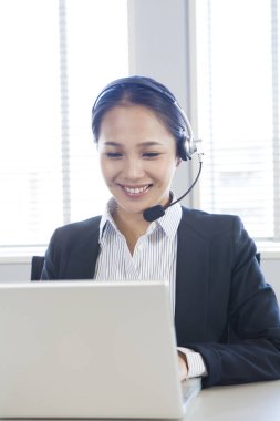 Ofisinde kulaklığı olan mutlu genç çağrı merkezi çalışanı portresi.