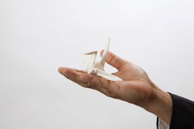 Erkek eli kağıt vinç, geleneksel Japon origami oyuncağı.