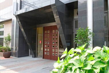 Bitkiler ve cam cepheli modern bina girişi