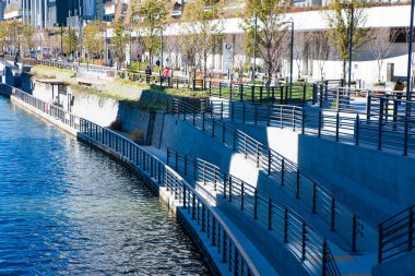 Yol, korkuluk ve yeşillik içeren modern liman parkı