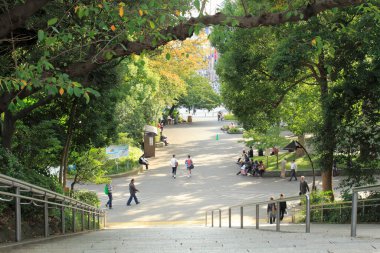 Japonya 'da yeşil yaz parkında yürüyen insanlar