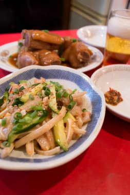 Kırmızı masada biralı Asya yemekleri.