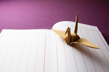  origami vinç ve not defteri masa arkasında 