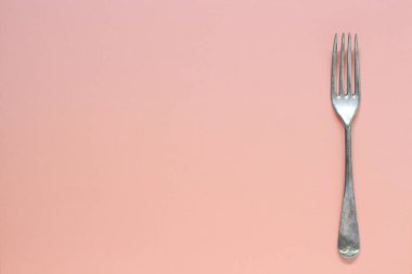 Açık pembe arkaplanda çatalın üst görünümü