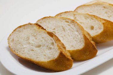 Beyaz zemin üzerinde taze kesilmiş ekmeğin yakın plan görüntüsü              
