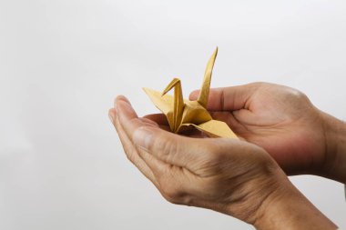Erkek eller el yapımı kağıt vinç, geleneksel Japon origami oyuncağı.