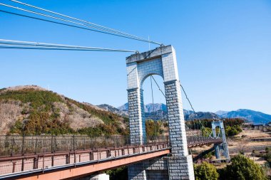 Japonya 'daki dağlarda nehir üzerinde köprü.