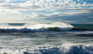 Dalgalar ve kabarık bulutlarla denizde fırtına