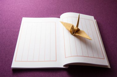  origami vinç ve not defteri masa arkasında 