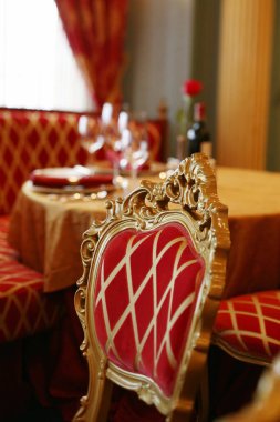 Süslü, altın kaplamalı koltukları olan lüks bir restoran.