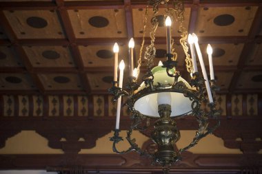 Ahşap tavandan sarkan süslü bir avize.