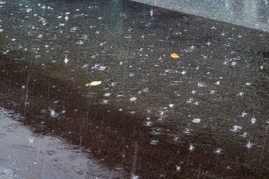 Şehrin kaldırımlarına ıslak yağmur yağıyor.