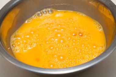 Metal karıştırma kabında çırpılmış yumurta.