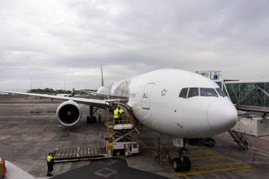 Arka planda havaalanında yolcu uçağı var.